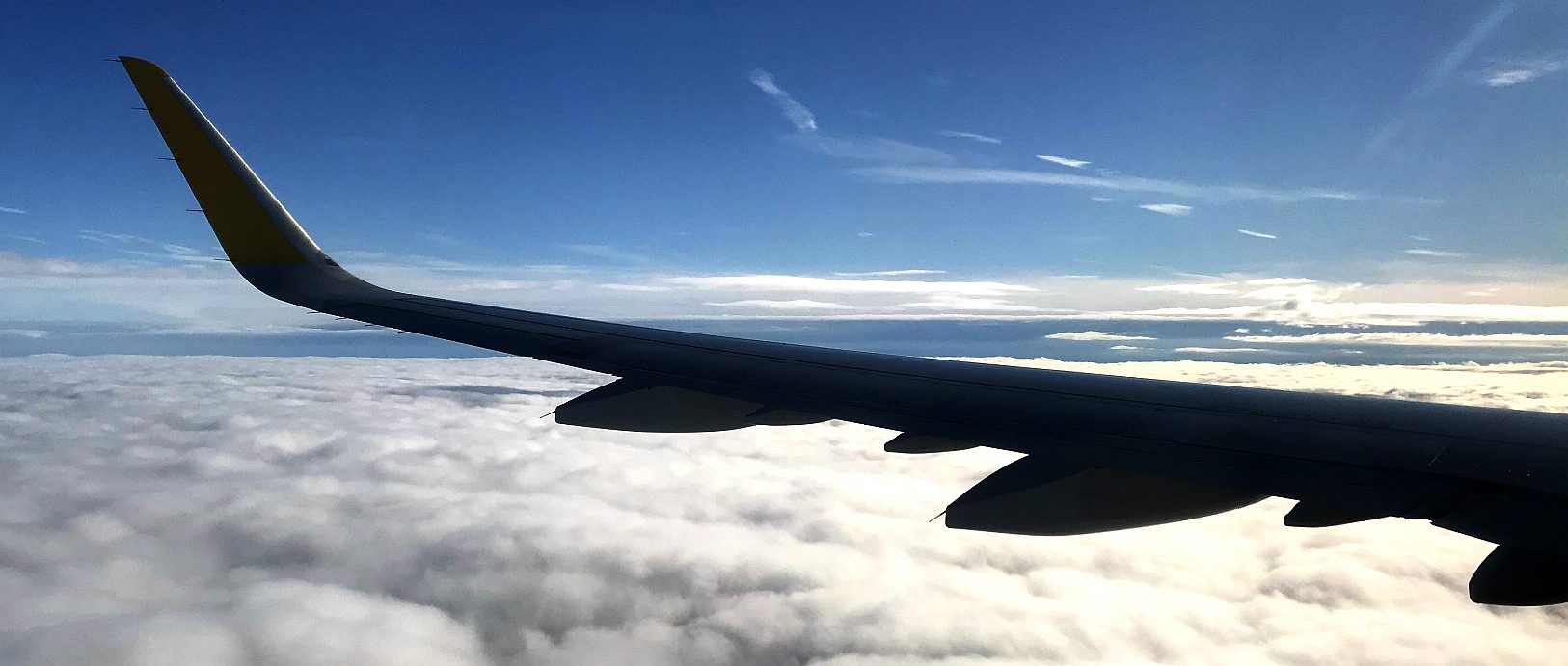 Wing tip of the Boeing Airbus set against a blue sky and soft clouds