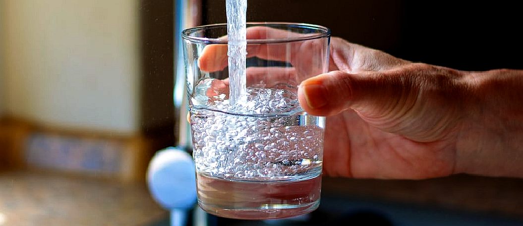 A glass of tapwater filling up